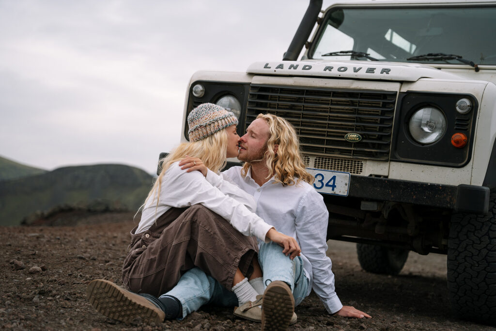Romantic kiss in front of the Land Rover during their hot springs elopement in Iceland
