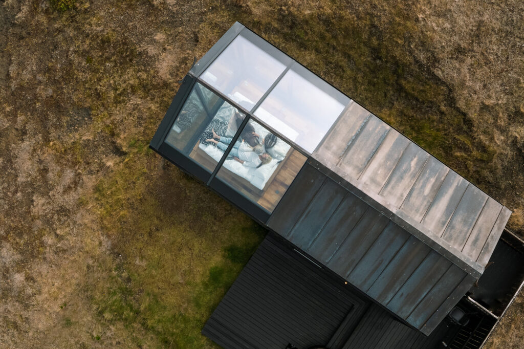 Aerial view of the couple at Panorama Glass Lodge surrounded by Icelandic landscapes during their hot springs elopement weekend
