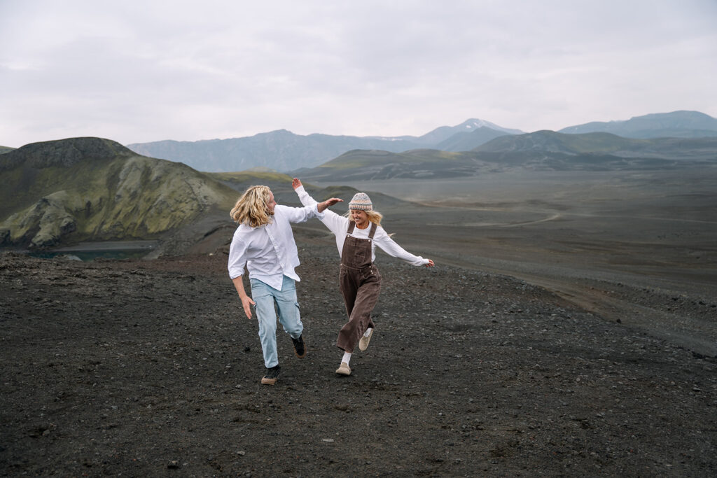 couple running through an Iceland crater in the highlands for their elopement