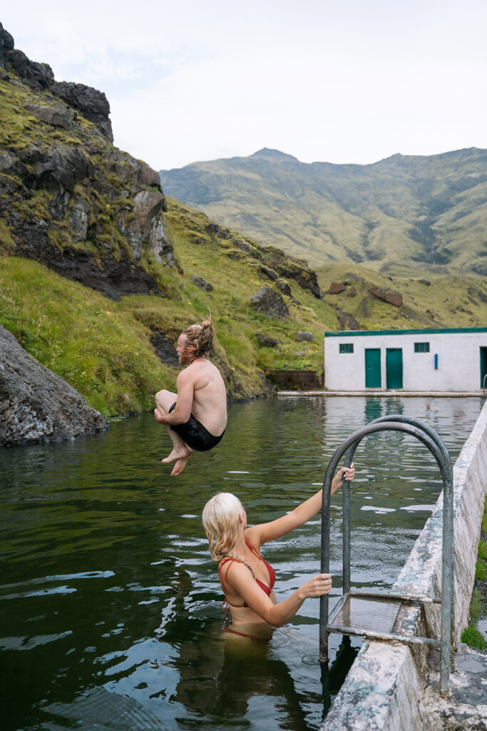 Playful splash during a post-elopement soak in an Icelandic hot spring