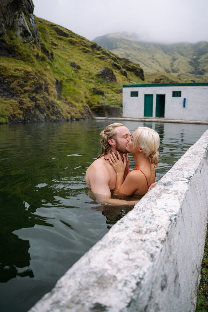 Couple soaking together in Seljavallalaug during their Iceland hot springs elopement