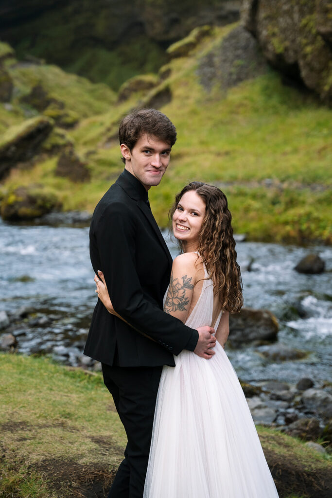 just married happy couple look at the photographer as they smile in iceland
