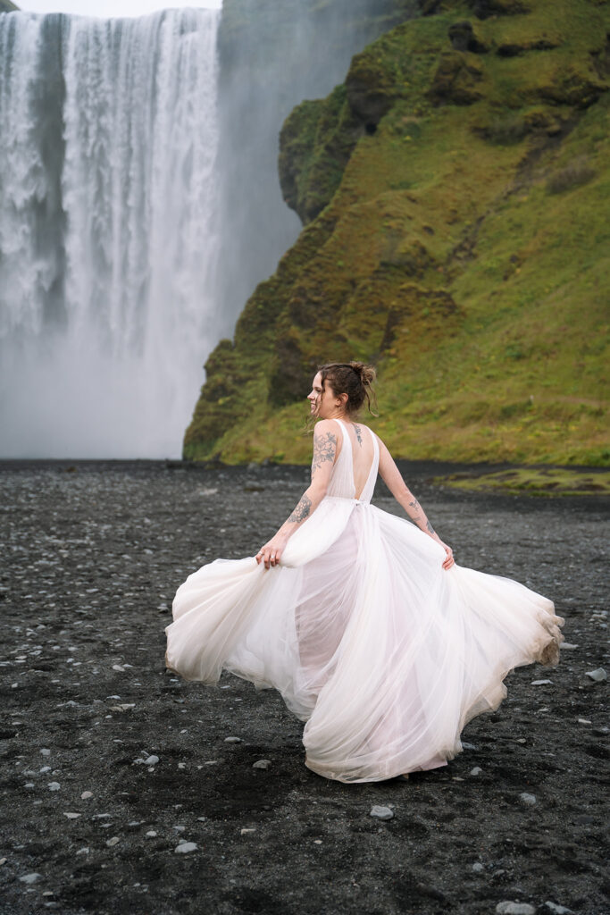 brides dress flows out beautifully at Skogasfoss waterfall